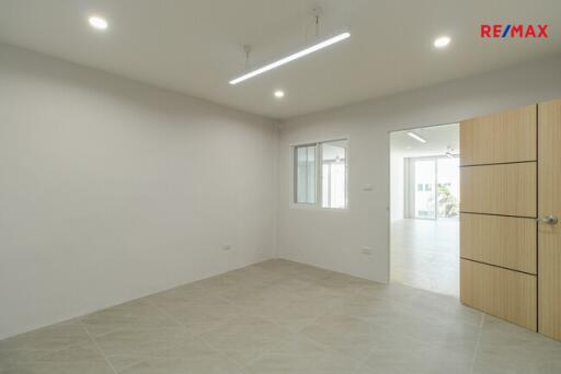 Empty living room with a window and door leading to another room