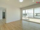 Spacious living room with wooden flooring and large windows