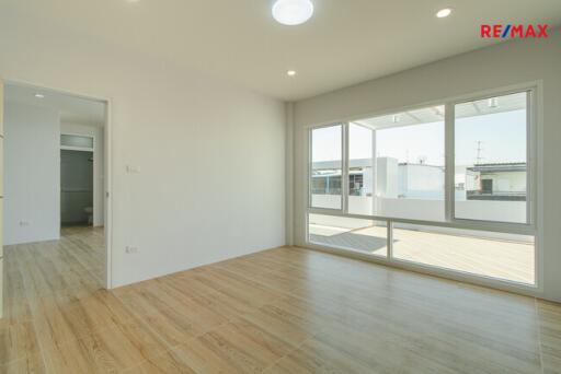 Spacious living room with wooden flooring and large windows