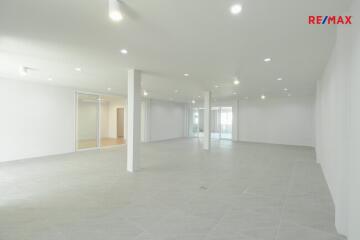 Spacious empty room with white walls and tile flooring