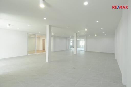 Spacious empty room with white walls and tile flooring