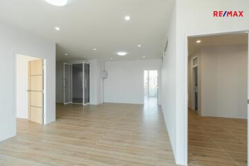 Spacious living area with wooden flooring and white walls