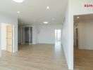 Spacious living area with wooden flooring and white walls