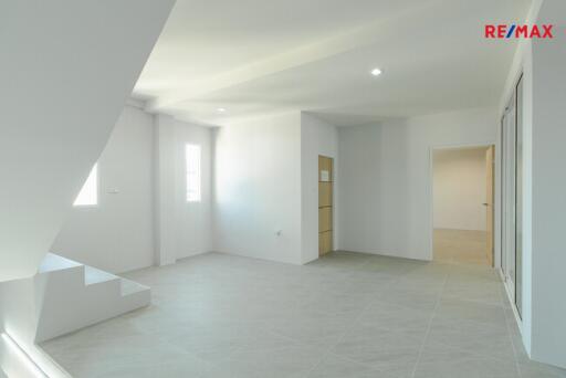 Spacious and bright living room with stairs leading to upper level