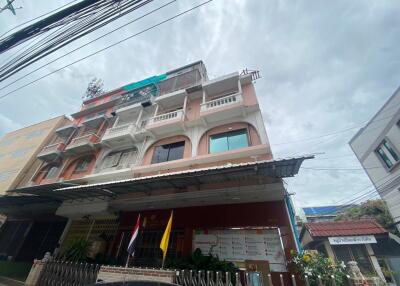 Front view of a multi-storey building with balconies and a covered entrance