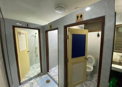 Shared bathroom area with multiple stalls and shower facilities