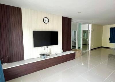 Modern living room with wall-mounted TV and clean tiled flooring