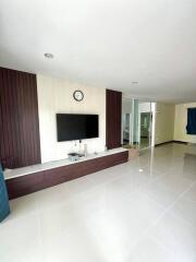 Modern living room with wall-mounted TV and clean tiled flooring