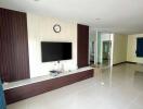 Modern living room with wall-mounted TV and clean tiled flooring