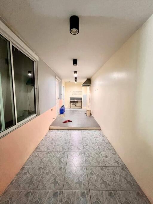 Corridor with tiled flooring and overhead lights