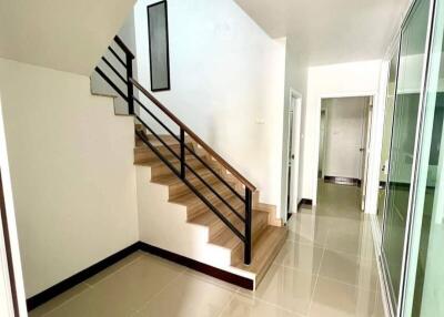 Bright hallway with staircase and tile flooring