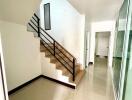 Bright hallway with staircase and tile flooring