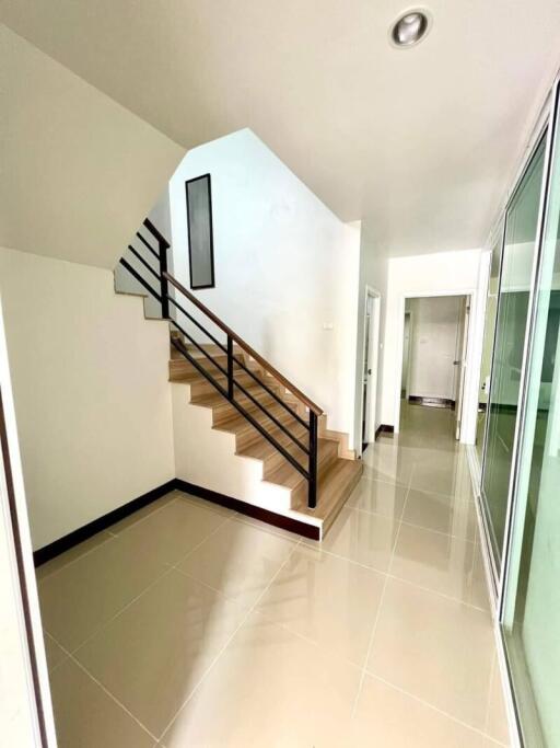 Bright hallway with staircase and tile flooring