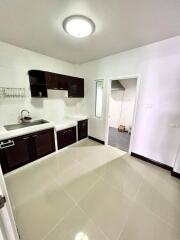 Modern kitchen with dark wood cabinets and white countertops