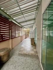 Spacious covered balcony with tiled floor and glass doors