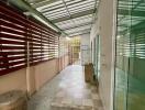 Spacious covered balcony with tiled floor and glass doors