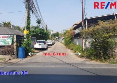 Street view with several cars parked along the side and residential buildings