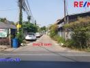 Street view with several cars parked along the side and residential buildings