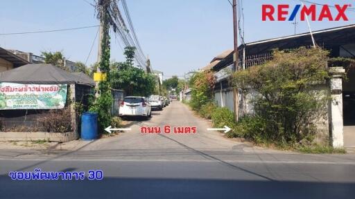 Street view with several cars parked along the side and residential buildings