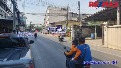 Outdoor neighborhood street view with people riding motorcycles and road signs