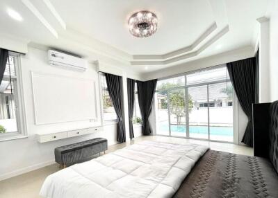 Modern bedroom with large windows, air conditioner, and outdoor view