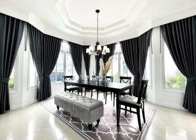 Elegant dining room with large windows, chandelier, and sophisticated decor