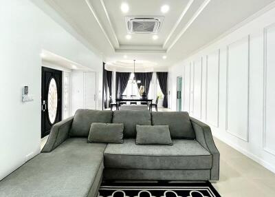 Spacious and modern living room with grey sofa and open dining area