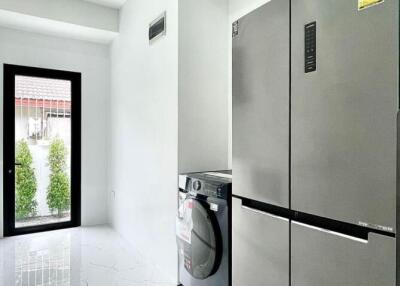 Modern kitchen with large refrigerator and washing machine