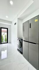 Modern kitchen with large refrigerator and washing machine