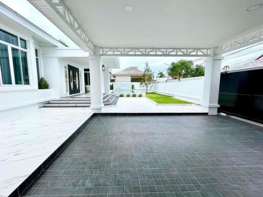 Spacious covered garage area with adjacent garden