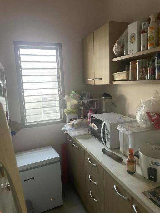 Small, cluttered kitchen with appliances and storage