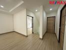 Spacious hallway with modern wooden flooring and doors