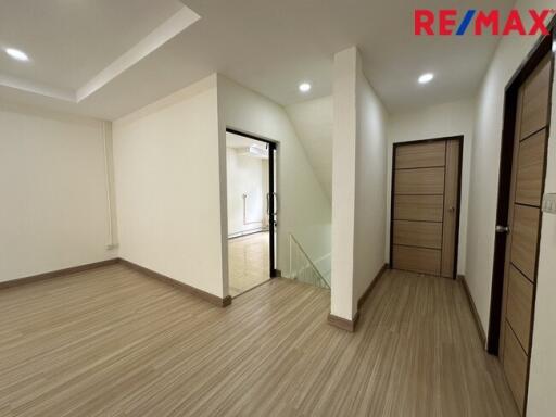 Spacious hallway with modern wooden flooring and doors