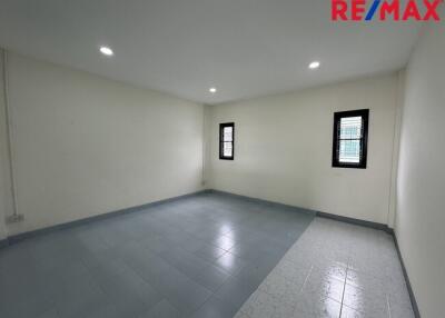 Empty bedroom with tiled floor and two windows