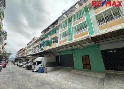 Street view of residential buildings with parked cars