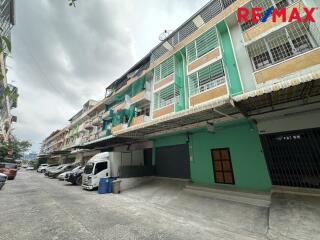 Street view of residential buildings with parked cars