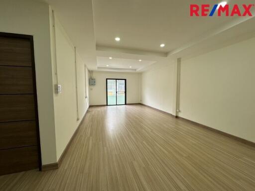 Spacious empty living room with wooden flooring and large window