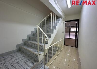 A well-lit staircase with a tiled floor