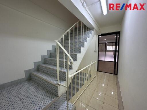 A well-lit staircase with a tiled floor