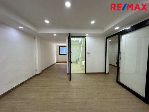 Empty spacious room with glass doors and wooden flooring