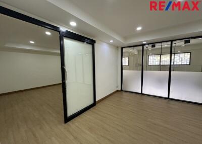 Spacious office area with wooden flooring and glass partitions