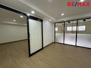 Spacious office area with wooden flooring and glass partitions