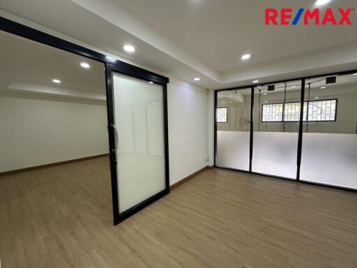 Spacious office area with wooden flooring and glass partitions