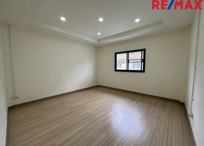 Spacious empty bedroom with wooden flooring and recessed lighting