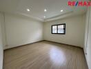 Spacious empty bedroom with wooden flooring and recessed lighting