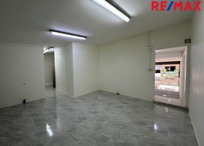 Spacious empty room with tiled floor and fluorescent lighting