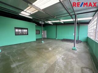 Spacious industrial or commercial space with large windows and high ceilings