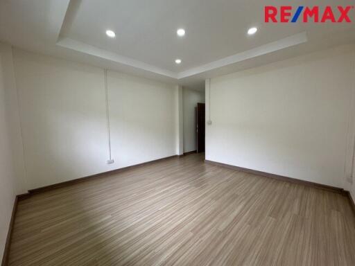 Spacious living area with wooden flooring and ceiling lights