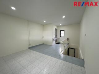 Spacious living area with stair access and modern lighting