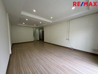 Spacious unfurnished living area with wooden flooring and recessed lighting